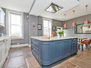 a kitchen with blue cabinets and a blue island at Low Seal House in Richmond