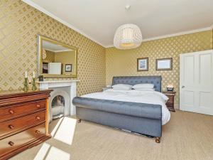 a bedroom with a blue bed and a fireplace at Low Seal House in Richmond +15 photos