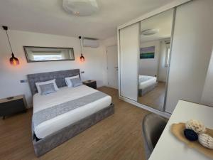a bedroom with a bed and a large mirror at Caia House in Ourondo