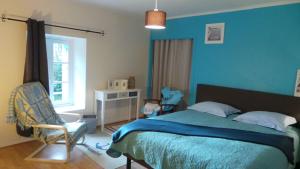 a bedroom with a bed and a chair and a window at Ti Bleunv-nevez in Moëlan-sur-Mer +9 photos