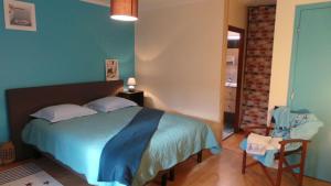 a bedroom with a bed and a chair in it at Ti Bleunv-nevez in Moëlan-sur-Mer