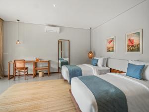 a hotel room with two beds and a table at Agra & Amurti Villas in Munggu