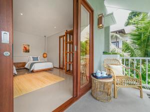 a bedroom with a bed and a balcony at Agra & Amurti Villas in Munggu