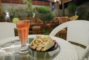 a glass table with a plate of food and a drink at Sambhariya Bagh Resort in Kānota