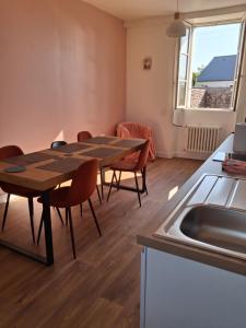 a kitchen and dining room with a table and a sink at Chambres d'hôtes Frehel in Fréhel +12 photos
