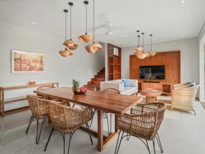 a dining room with a wooden table and rattan chairs at Agra & Amurti Villas in Munggu