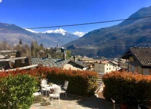 a patio with a table and chairs and mountains at A Casa di Zia Renny in Châtillon