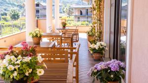 a balcony with tables and chairs and flowers in pots at Magna Grecia B&B e Appartamenti in Caulonia Marina
