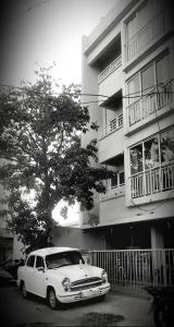 a white car parked in front of a building at GURUDEV The Peace Home HOME STAY in Kolhapur
