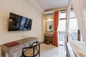 a bedroom with a tv and a bed and a window at Radateeree Boutique Resort in Chiang Mai
