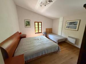 a bedroom with a large bed and a window at Mas Ferrieres Saint Laurent in Saint-Laurent-le-Minier