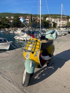 a scooter parked next to a marina with boats at Holiday House Bribir in Bribir