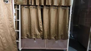 a pair of curtains on a bed in a room at Suvidha Dormitory Hotel in Bhuj
