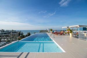 a swimming pool with a view of the ocean at Mosaic Condominium - Mae Phim in Ban Tha Fat
