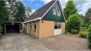 a house with a green roof and a garage at Huisje 47 | 8 persons in Gasselte