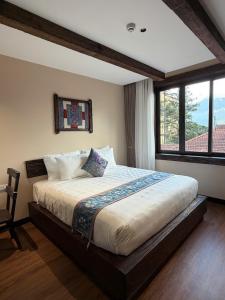 a bedroom with a large bed with a window at The Mysteri Sapa in Sapa