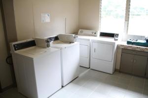 a laundry room with white washers and dryers at DW Motel in Koror