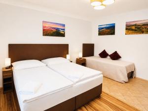 a bedroom with two beds and paintings on the wall at Kovárna Klapý pod Hazmburkem - České středohoří in Klapý