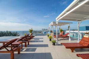 a deck with benches and tables on a roof at Mosaic Condominium - Mae Phim in Ban Tha Fat
