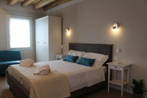 a bedroom with a large bed with blue pillows at Cà Dei Nonni in Castelfranco Veneto