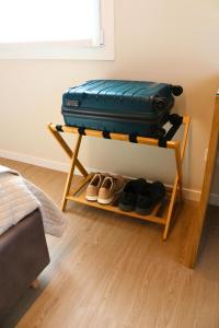 a shelf with a suitcase and shoes on it at Cà Dei Nonni in Castelfranco Veneto