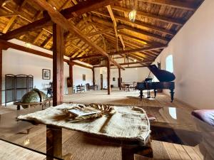a living room with a table and a piano at Malom Loft Apartman in Veszprém +9 photos