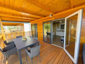 a wooden deck with a table and chairs on it at Mobile homes Camp Kozica in Sibinj Krmpotski