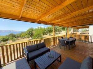 a porch with a couch and a table on a deck at Mobile homes Camp Kozica in Sibinj Krmpotski