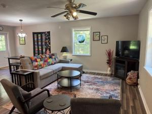 a living room with a couch and a tv at Peace in the Holler in Eureka Springs