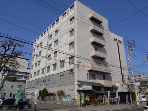 a tall white building on the corner of a street at New Grande Mimatsu in Takamatsu