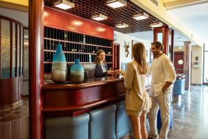a group of people standing at a counter in a store at Hotel Caravel in Limone sul Garda +179 photos