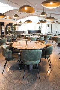 a restaurant with a wooden table and green chairs at The Avenue in Whanganui