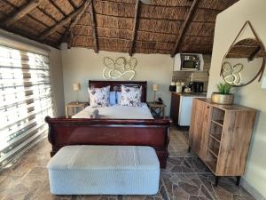 a bedroom with a bed and a stool in a room at Bosveld In Die Stad Lodge in Alberton +89 photos