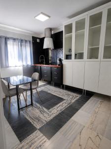 a kitchen with white cabinets and a glass table at The Simpsons in Seville in Mairena del Aljarafe +4 photos