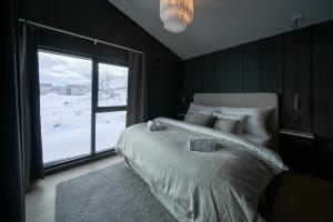 a bedroom with a large bed and a large window at Fredvang Lodge, Lofoten in Fredvang