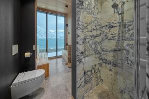 a bathroom with a toilet and a glass shower at Fredvang Lodge, Lofoten in Fredvang +49 photos