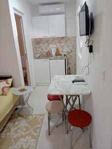 a small kitchen with a table and two stools at Apartmani CECA 012 Sutomore in Sutomore