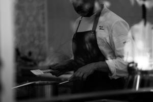 a man in a kitchen holding a spatula at La Pampa Relais & Spa in Melizzano +124 photos