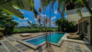 a swimming pool in the middle of a yard with trees at Villa Dew Canggu in Kerobokan