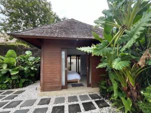 a small room with a bed in a garden at Villa Dew Canggu in Kerobokan +82 photos