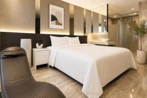 a bedroom with a large white bed and a chair at Guwol Hotel in Incheon +69 photos