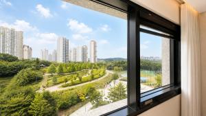 a window with a view of a park and buildings at Guwol Hotel in Incheon