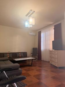 a living room with a couch and a table and a tv at Tinano in Kuchkisabano