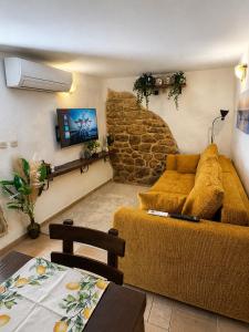 a living room with a couch and a stone wall at Biba Holiday in Omišalj