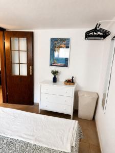 a bedroom with a bed and a dresser and a door at Biba Holiday in Omišalj