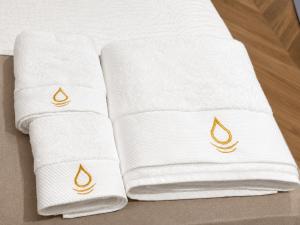 three white towels with a fire symbol on them at The Originals Residence, Les Sources Callou, Vichy in Vichy +74 photos