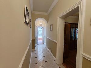 a hallway of a home with a door and a tile floor at Caradoc House in Muizenberg