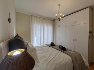 a bedroom with a bed and a chandelier at Caradoc House in Muizenberg