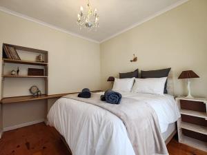 a bedroom with a large bed with towels on it at Caradoc House in Muizenberg +30 photos