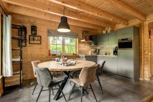 a kitchen and dining room with a table and chairs at Luxe, rust en ruimte bij de Veluwse Vijf in Epe in Epe